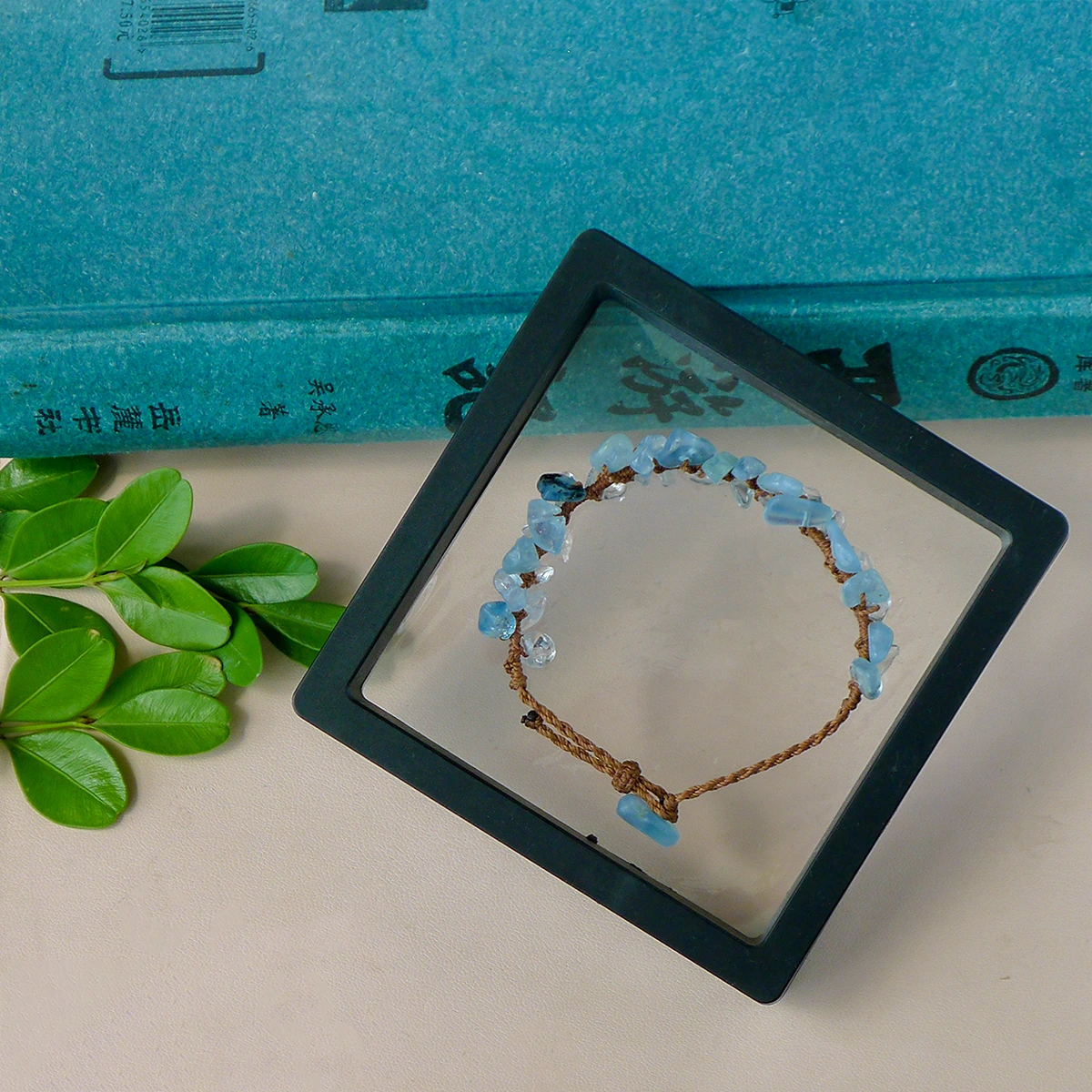 Aquamarine and clear quartz macrame bracelet styled in a framed still life setting