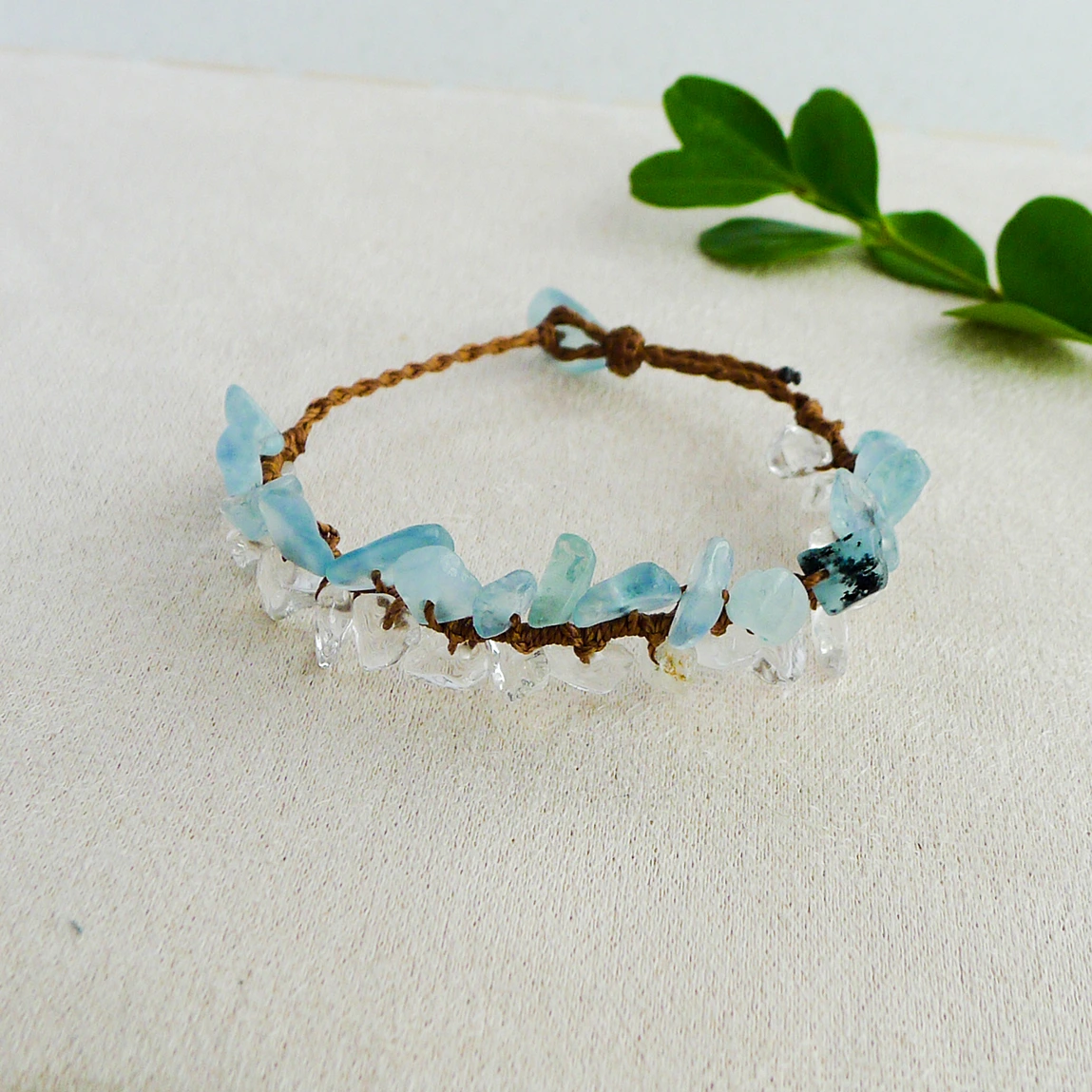 Adjustable aquamarine and clear quartz bracelet styled with green leaves