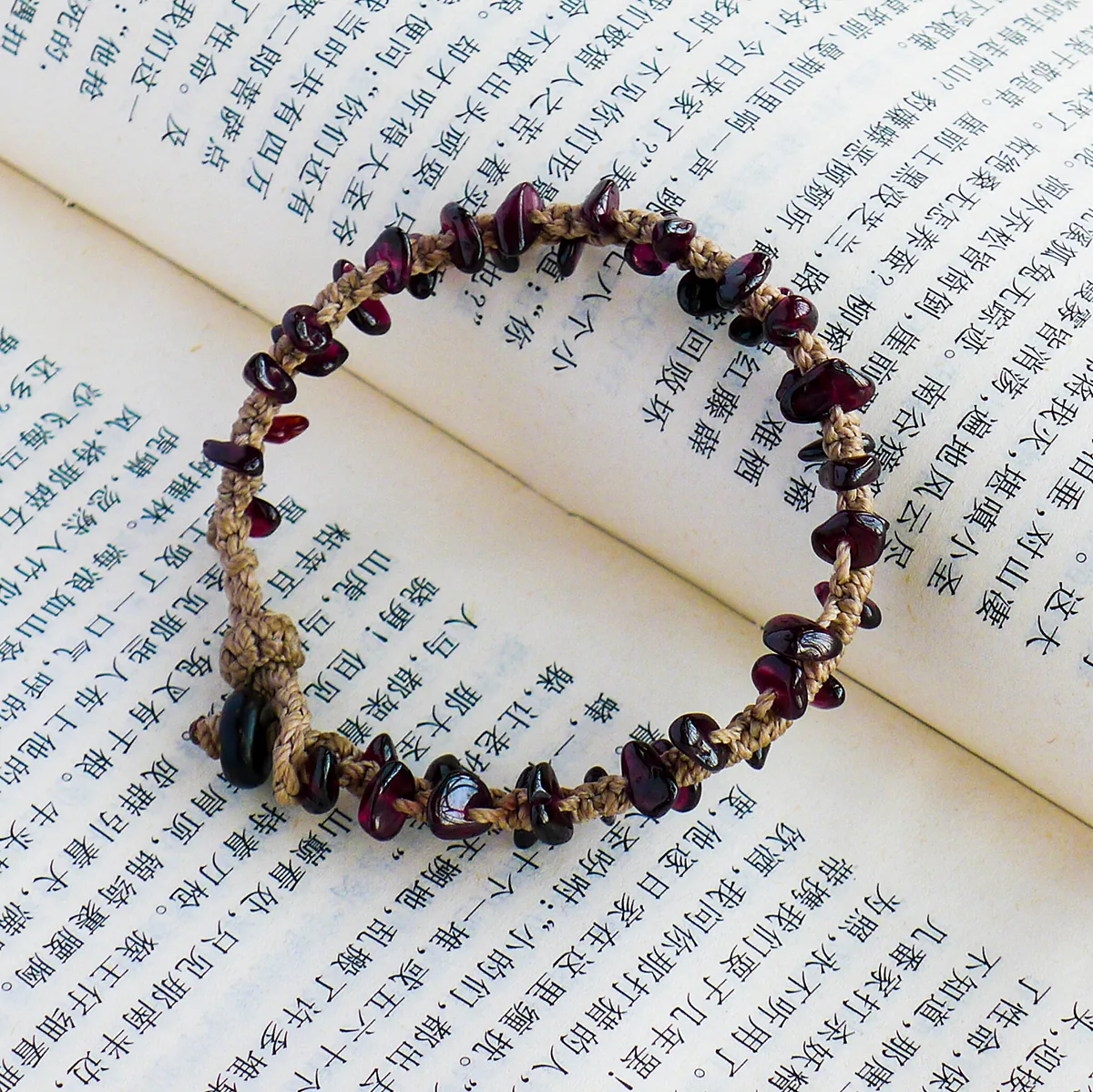 Natural garnet chip bracelet arranged on open book pages
