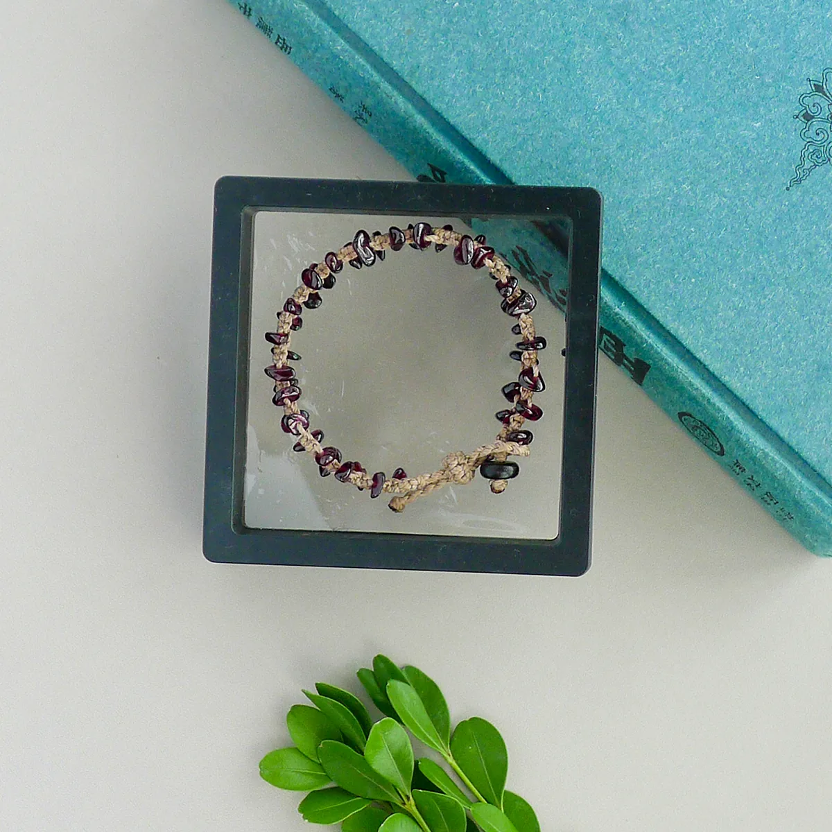 Handmade garnet chip bracelet in a quiet framed still-life setting